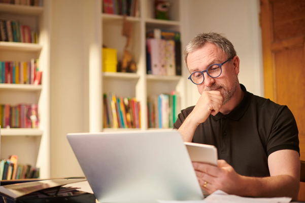 A contractor sat at their desk looking at a digital tablet