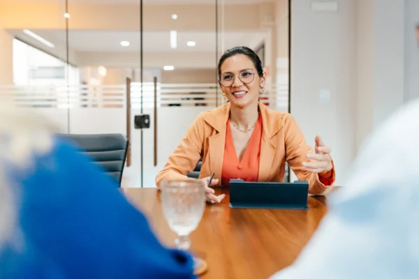 A contractor sat at a desk having a discussion with two other people who are mostly out of frame